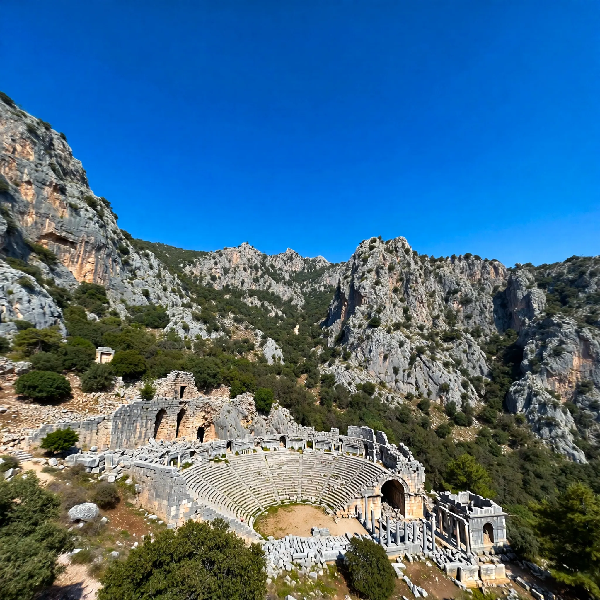 Ruiny Termessos w górach Taurus, ukazujące starożytną inżynierię w otoczeniu dramatycznego krajobrazu i zieleni.